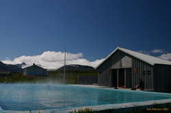 A glacier and a hot pool, under a blue sky