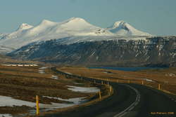 Winding down an empty road towards the head of Hvalfjörður, Botnsúla and Syðstasúla overhead
