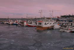 Cold sunset, ice in the small boat harbour
